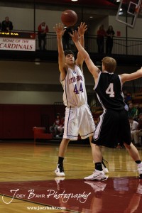 Otis-Bison Cougar Brandon Pechanec (#44) throws a pass over Ellsworth Bearcat Josh Bahr (#4) during the 2012 Hoisington Winter Jam Basketball Tournament.