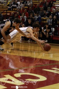 Otis-Bison Cougar Brandon Pechanec (#44) dives for a ball as does Ellsworth Bearcat McGregor Jones (#13) during the 2012 Hoisington Winter Jam Basketball Tournament.