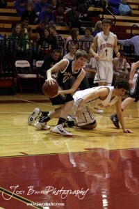 Ellsworth Bearcat Matthew Keener (#0) steals the ball from Otis-Bison Cougar Brandon Pechanec (#44) during the 2012 Hoisington Winter Jam Basketball Tournament.