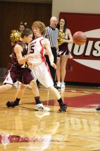 Victoria Knight Bryan Dome (#21) passes the basketball around Clint Glaser (#15) of the Ellsworth Bearcats at the 2012 Hoisington Winter Jam Basketball Tournament.