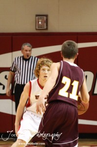 Ellsworth Bearcat Clint Glaser (#15) follows Victoria Knight Bryan Dome (#21) on defense at the 2012 Hoisington Winter Jam Basketball Tournament.