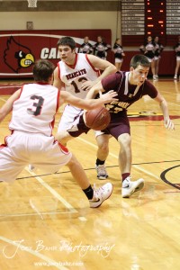 Tanner Hobbs (#33) of the Victoria Knights drives through Ellsworth Bearcats Shane Wilson (#3) and McGregor Jones (#13) at the 2012 Hoisington Winter Jam Basketball Tournament.