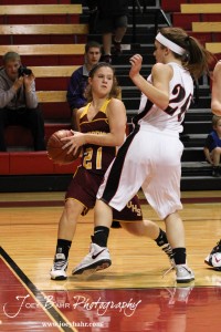 Ashley Dome (#21) of the Victoria Lady Knights drives against Ellsworth Lady Bearcat Connor Davis (#20) at the 2012 Hoisington Winter Jam