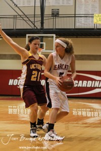 Ellsworth Lady Bearcat Rachel Herzog (#5) looks for a teammate to pass to while Victoria Lady Knight Ashley Dome (#21) defends her at the 2012 Hoisington Winter Jam Basketball Tournament.