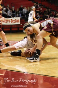 Ellsworth Lady Bearcat Lainey Dunn (#33) and Victoria Lady Knight Brooke Schmidt (#12) battle over the basketball at the 2012 Hoisington Winter Jam Basketball Tournament.