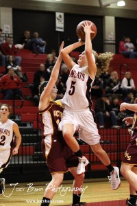 Ellsworth Lady Bearcat Rachel Herzog (#5) goes up for a layup while Victoria Lady Knight Brooke Pfanenstiel (#14) attempts to block her at the 2012 Hoisington Winter Jam Basketball Tournament.