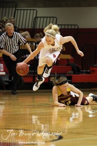 Ellsworth Lady Bearcat Halle Connally (#10) jumps over Kristin Huser (#10) of the Victoria Lady Knights at the 2012 Hoisington Winter Jam Basketball Tournament.