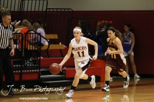 Brenn Cravens (#11) of the Ellsworth Lady Bearcats drives down the court while Victoria Lady Knight Ashley Dome (#21) trails behind at the 2012 Hoisington Winter Jam Basketball Tournament.
