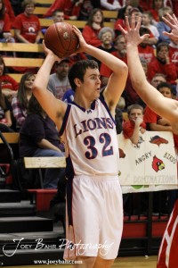 Minneapolis Lion Zach Allison (#32) looks for a teammate to pass the basketball to against the Hoisington Cardinals at the 2012 Hoisington Winter Jam Basketball Tournament.
