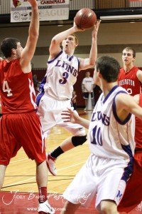 Minneapolis Lion Andrew Yoxall (#3) tries to take a shot over Hoisington Cardinal Cody Stetler (#4) at the 2012 Hoisington Winter Jam Basketball Tournament.
