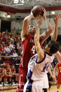 Cody Stetler (#4) of the Hoisington Cardinals goes up for a shot over the defense of Minneapolis Lion Alex Johnson (#10) at the 2012 Hoisington Winter Jam Basketball Tournament.