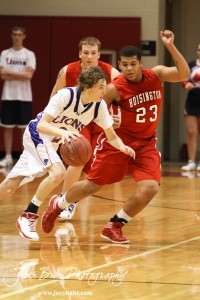 Josh Macy (#2) of the Minneapolis Lions drives past Taylor Crawford (#23) of the Hoisington Cardinals at the 2012 Hoisington Winter Jam Basketball Tournament.