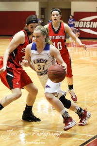 Tori Ptacek (#31) of the Russell Lady Broncos drives past Hoisington Lady Cardinals Mallory Flagor (#32) and Jordin Greer (#10) at the 2012 Hoisington Winter Jam Basketball Tournament.