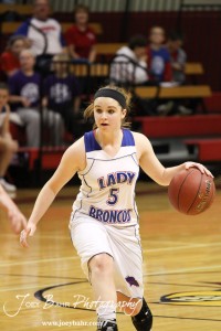 Alex Ptacek (#5) of the Russell Lady Broncos dribbles the basketball against the Hoisington Lady Cardinals at the 2012 Hoisington Winter Jam Basketball Tournament.