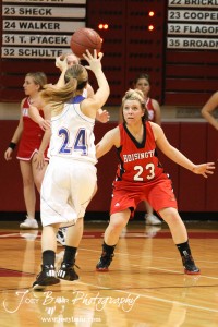 Hoisington Lady Cardinal Blakelee Cooper (#23) defends against Russell Lady Bronco Kaitlyn Walker (#24) at the 2012 Hoisington Winter Jam Basketball Tournament.