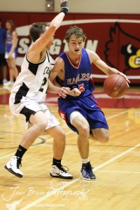 Kyle Blakeslee (#15) of the Ellinwood Eagles drives against LaCrosse Leopard Tayler Stull (#22) at the 2012 Hoisington Winter Jam Basketball Tournament.