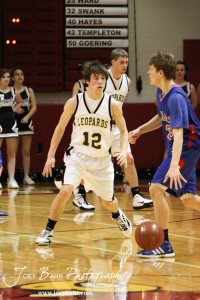 Clayton Basgall (#12) of the LaCrosse Leopards defends against Ellinwood Eagle Cody Isern (#23) at the 2012 Hoisington Winter Jam Basketball Tournament.