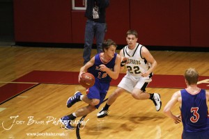 Ellinwood Eagle Kyle Blakeslee (#15) drives past Tayler Stull (#22) of the LaCrosse Leopards at the 2012 Hoisington Winter Jam Basketball Tournament.