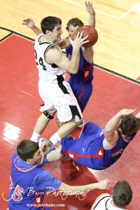 Kip Keeley (#24) of the LaCrosse Leopards takes a shot while Ellinwood Eagle Garrett Hayes (#40) falls away while attempting to take a charge at the 2012 Hoisington Winter Jam Basketball Tournament.