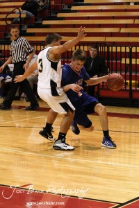 Patrick Ringering (#2) of the Ellinwood Eagles drives against Derrick Depperschmidt (#3) of the LaCrosse Leopards at the 2012 Hoisington Winter Jam Basketball Tournament.