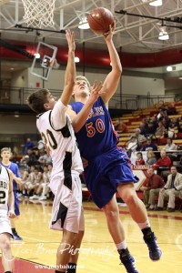 Marshall Jay (#20) of the LaCrosse Leopards tries to block Ian Goering (#50) of the Ellinwood Eagles at the 2012 Hoisington Winter Jam Basketball Tournament.