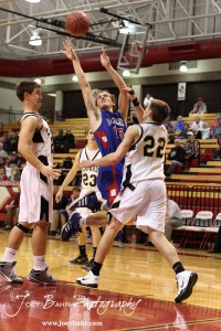 Ellinwood Eagle Kyle Blakeslee (#15) takes a shot against the defense of Kip Keeley (#24) and Tayler Stull (#22) of the LaCrosse Leopards at the 2012 Hoisington Winter Jam Basketball Tournament.