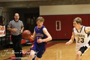 Tanner Swank (#32) of the Ellinwood Eagles drives past LaCrosse Leopard Austin Webs (#23) at the 2012 Hoisington Winter Jam Basketball Tournament.