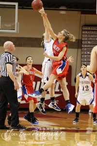 Otis-Bison Lady Cougar Kim Pechanec (#32) and Ellinwood Lady Eagle Lindsey Zink (#24) go up for the tipoff of their game at the 2012 Hoisington Winter Jam Basketball Tournament.