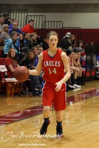 Brooke Panning (#14) of the Ellinwood Lady Eagles dribbles down the side of the court against the Otis-Bison Lady Cougars at the 2012 Hoisington Winter Jam Basketball Tournament.