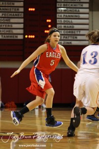 Jenna Snell (#5) of the Ellinwood Lady Eagles defends against Otis-Bison Lady Cougar Demi Bartonek (#13) at the 2012 Hoisington Winter Jam Basketball Tournament.