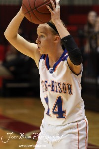 Dekota Nelson (#14) of the Otis-Bison Lady Cougars looks to make a pass against the Ellinwood Lady Eagles at the 2012 Hoisington Winter Jam Basketball Tournament.