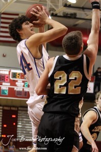Brandon Pechanec (#44) of the Otis-Bison Cougars goes up for a shot over the defense of LaCrosse Leopard Tayler Stull (#22) at the 2012 Hoisington Winter Jam Basketball Tournament.