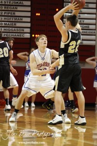 Otis-Bison Cougar Patrick Piper (#22) defends Tayler Stull (#22) of the LaCrosse Leopards at the 2012 Hoisington Winter Jam Basketball Tournament.