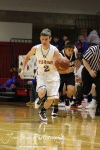 Kole Urban (#2) of the Otis-Bison Cougars drives past Derrick Depperschmidt (#3) of the LaCrosse Leopards at the 2012 Hoisington Winter Jam Basketball Tournament.