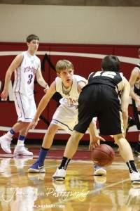 Otis-Bison Cougar Justus Bartonek (#1) defends LaCrosse Leopard Clayton Basgall (#12) at the 2012 Hoisington Winter Jam Basketball Tournament.