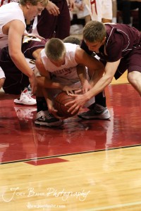 Trent Schremmer (#2) of the Hoisington Cardinals battles for the ball against a pair of Victoria Knights at the 2012 Hoisington Winter Jam Basketball Tournament.