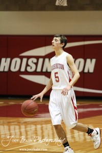 Ryan Becker (#5) of the Hoisington Cardinals dribbles the ball down the court against the Victoria Knights at the 2012 Hoisington Winter Jam Basketball Tournament.