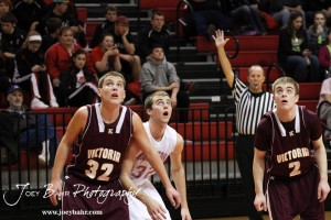 Hoisington Cardinal Derrick Kaiser (#32) and Victoria Knights Lane Braun (#32) and Corey Dinkel (C) (#2) watch a free throw attempt at the 2012 Hoisington Winter Jam Basketball Tournament.