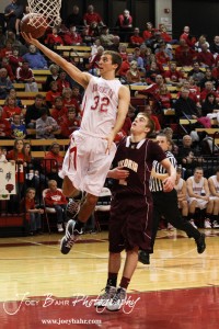 Hoisington Cardinal Derrick Kaiser (#32) goes up for a layup past the defense of Victoria Knight Corey Dinkel (#2) at the 2012 Hoisington Winter Jam Basketball Tournament.