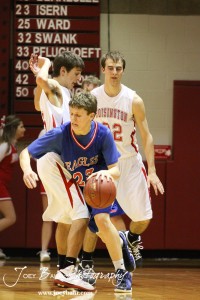 Cody Isern (#23) of the Ellinwood Eagles drives around Hoisington Cardinal Ryan Becker (#5) at the Hoisington Activities Center in Hoisington, Kansas on February 10, 2012.  Photo: Joey Bahr