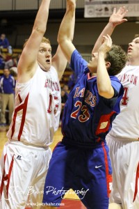Darin Poland (#15) of the Hoisington Cardinals tries to block a shot from Ellinwood Eagle Cody Isern (#23) at Hoisington Activities Center in Hoisington, Kansas on February 10, 2012.  Photo: Joey Bahr