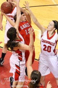 Ellinwood Lady Eagle Rachel Doll (#15) drives against the defending of Hoisington Lady Cardinals Mallory Flagor (#32) and Brandy Wondra (#20) at the Hoisington Activities Center in Hoisington, Kansas on February 10, 2012.  Photo: Joey Bahr