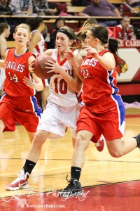 Hoisington Lady Cardinal Jordin Greer (#10) drives through the defense of Ellinwood Lady Eagles Brooke Panning (#14) and Kenzie Corbet (#21) at the Hoisington Activities Center in Hoisington, Kansas on February 10, 2012.  Photo: Joey Bahr
