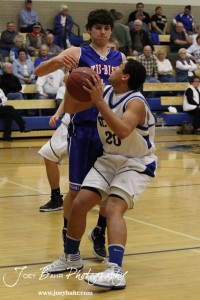 OB_Boys_vs_St_John_BB_2-21-12_0003 Spencer Nusser (#20) of the St. John Tigers goes up for a shot against the defense of Otis-Bison Cougar Brandon Pechanec (#44) at St. John High School in St. John, Kansas on February 21, 2012. Photo: Joey Bahr