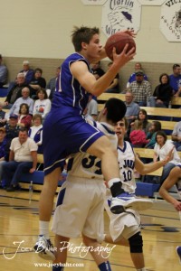 OB_Boys_vs_St_John_BB_2-21-12_0010 Otis-Bison Cougar Dylan Wissman (#11) goes for a layup over the defense of St. John Tiger Zuriel Reyes (#34) at St. John High School in St. John, Kansas on February 21, 2012. Photo: Joey Bahr