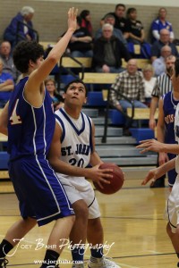 OB_Boys_vs_St_John_BB_2-21-12_0044 Spencer Nusser (#20) of the St. John Tigers goes up for a shot against Otis-Bison Cougar Brandon Pechanec (#44) at St. John High School in St. John, Kansas on February 21, 2012. Photo: Joey Bahr