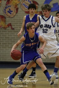 OB_Boys_vs_St_John_BB_2-21-12_0050 Justus Bartonek (#1) of the Otis-Bison Cougars dribbles around St. John Tiger Dean Wade (#32) at St. John High School in St. John, Kansas on February 21, 2012. Photo: Joey Bahr