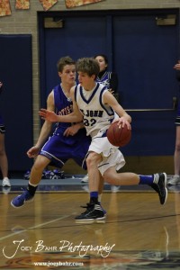 OB_Boys_vs_St_John_BB_2-21-12_0096 St. John Tiger Dean Wade (#32) drives past Otis-Bison Cougar Dylan Wissman (#11) at St. John High School in St. John, Kansas on February 21, 2012. Photo: Joey Bahr