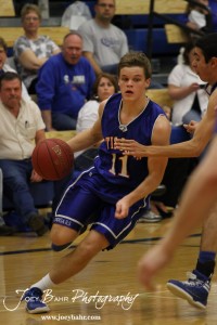 OB_Boys_vs_St_John_BB_2-21-12_0117 Dylan Wissman (#11) of the Otis-Bison Cougars drives past the St. John Tigers defense at St. John High School in St. John, Kansas on February 21, 2012. Photo: Joey Bahr