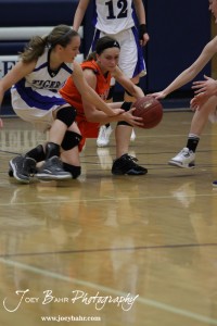 Otis-Bison Lady Cougar Hannah Bannister (#23) tries to keep the basketball away from St. John Lady Tigers defender Tara Christie (#15) at St. John High School in St. John, Kansas on February 21, 2012.  Photo: Joey Bahr